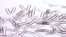 Paper clips on white background rotating