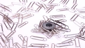 Paper clips and magnet on white background rotating 