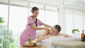 Asian woman masseuse talking and massaging shoulders and back of woman in white towel lying on massage bed getting relaxing massage therapy at spa salon. Relaxing back massage by woman therapist - Powered by Shutterstock - Get 15% off with code: PIKWIZARD15