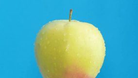 An apple in water drops rotates on a blue background. Vegetarian food concept - Powered by Shutterstock - Get 15% off with code: PIKWIZARD15