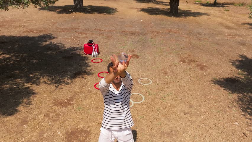 Male performer Juggling a crystal ball in an Olive tree plantation
