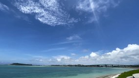 TOMIGUSUKU, OKINAWA, JAPAN - AUGUST 2021 : View of Senaga island and beach (Ocean or sea) in daytime. Clear blue summer sky and clouds. Holiday, vacation and resort concept video. Time lapse shot.