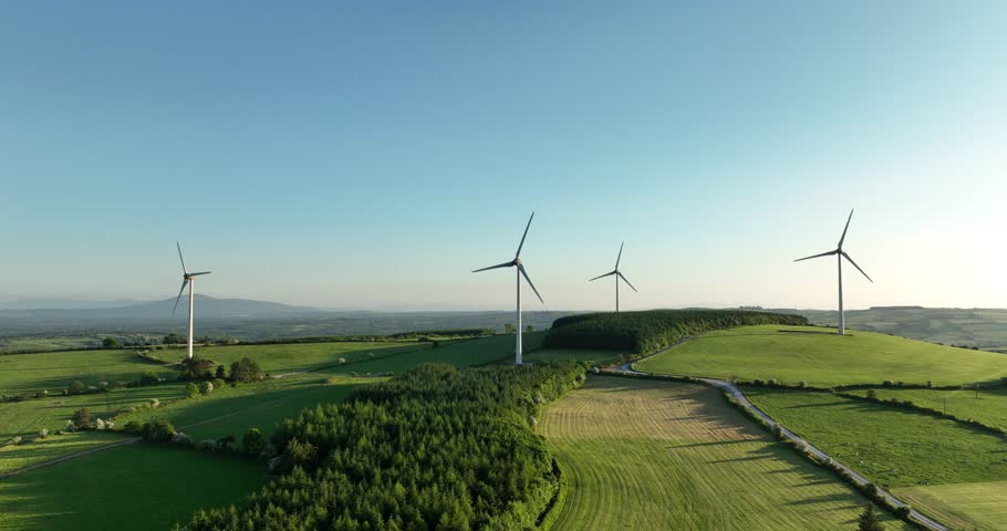 An aerial view of a powerful wind farm for energy production under a sunset