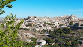 Panorama of the ancient city of Toledo on the banks of the Tagus River on a sunny day against the blue sky. Capital of the province of Toledo and  autonomous community of Castilla–La Mancha, Spain. 4K