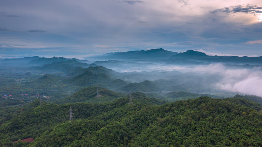 4K motion time lapse video aerial view morning scenery Mist flowing over the high mountains The movement of fog and clouds, Pang Puey, Mae Moh, Lampang, Thailand