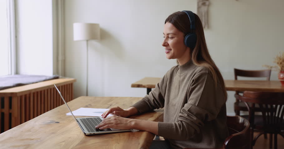 Woman in headphones hold on-line conference with client using laptop and video call application working remotely, provide professional online counselling and information at virtual meeting in office Royalty-Free Stock Footage #1105424369