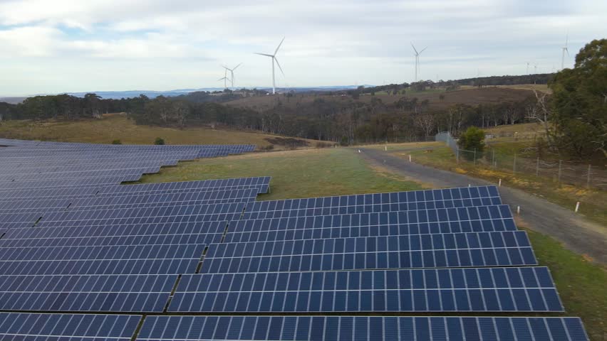 Aerial drone view of the hybrid Gullen Solar Farm and Gullen Range Wind Farm for renewable clean energy supply located at Bannister in the Upper Lachlan Shire, NSW, Australia  Royalty-Free Stock Footage #1105436515