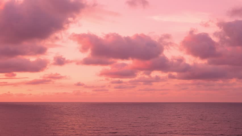 Beautiful Sunset Sky over Calm Ocean, Fluffy Clouds Sun Pink Lilac Orange Red Skyscraper, Slow Motion, Colorful Seascape. Travel, Vacation. Amazing Sunset Cloudy Sky and Sea. Evening Summer Sky.