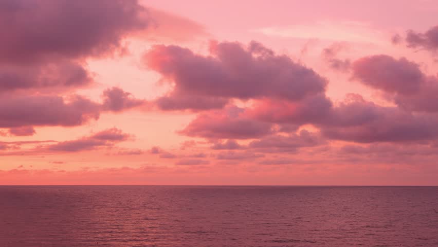 Beautiful Sunset Sky over Calm Ocean, Fluffy Clouds Sun Pink Lilac Orange Red Skyscraper, Slow Motion, Colorful Seascape. Travel, Vacation. Amazing Sunset Cloudy Sky and Sea. Evening Summer Sky.