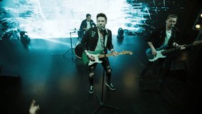 Jib shot of a rock band playing the gig during concert on stage of a large venue, surrounded by bright flashing stage lights - Powered by Shutterstock - Get 15% off with code: PIKWIZARD15