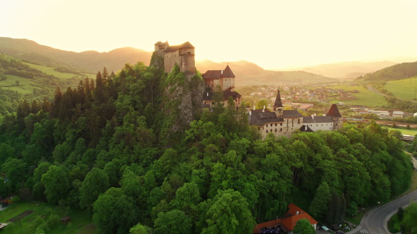 Aerial view of the Orava castle at sunrise in Slovakia. Medieval Oravsky Hrad castle on high and steep cliffs by the Orava River. Beautiful morning drone footage Royalty-Free Stock Footage #1105445341