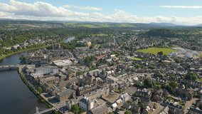 Aerial drone video of the town center of Inverness in western Scotland. The river Ness runs through the center and there are some churches around the river.