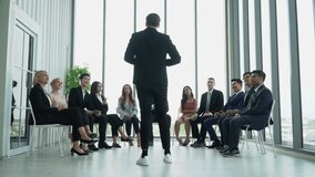 rear view of businessman standing speech motivation conference in seminar. executive man presentation in circle meeting at office on window with audience applauding . raise hand up to motivate - Powered by Shutterstock - Get 15% off with code: PIKWIZARD15
