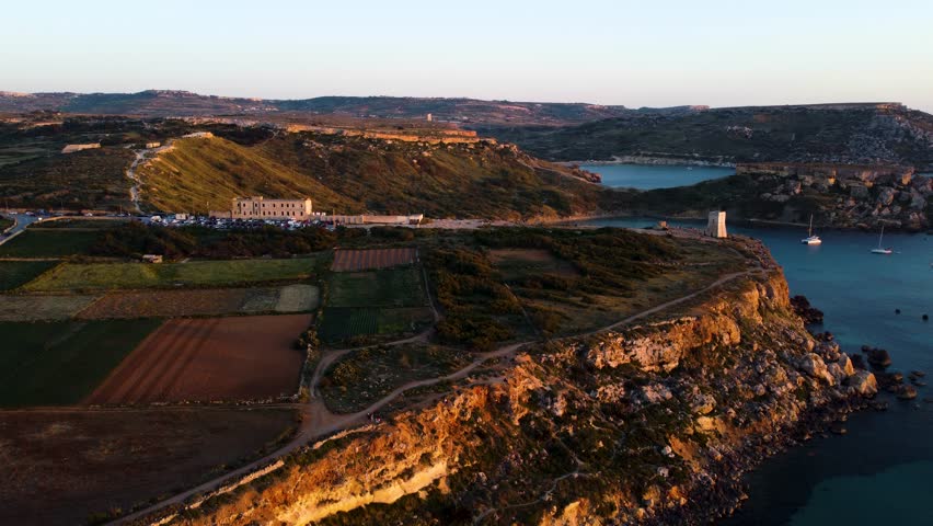 golden bay beach malta, golden hour sunset landscape, republic of malta, horizon, ocean, limestone, aerial drone overview shot.