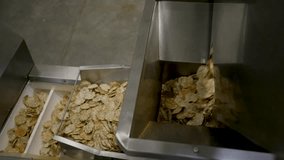 Close shot of a einkorn chips going trough a machine