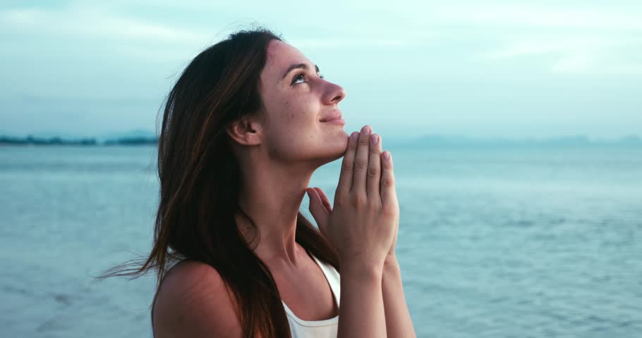 Happy woman praying to God looking at sky with hope. Woman praying at sea in the evening. Pure love concept. Profile of caucasian woman folding her hands into praying gesture. Faith in God Royalty-Free Stock Footage #1105461291