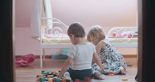 Cute little boy and girl playing with toy blocks. Shoot on Digital Cinema Camera in 4K - ProRes 422 codec.