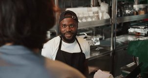 Doner worker. A Black person in a black cap takes an order on an electronic guy against the background of a doner market. Service in a fast food restaurant