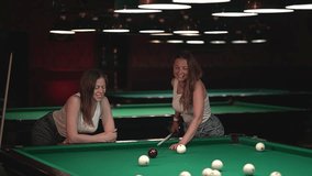 two women play billiards. slow motion video. two women in a bar. High quality Full HD video recording