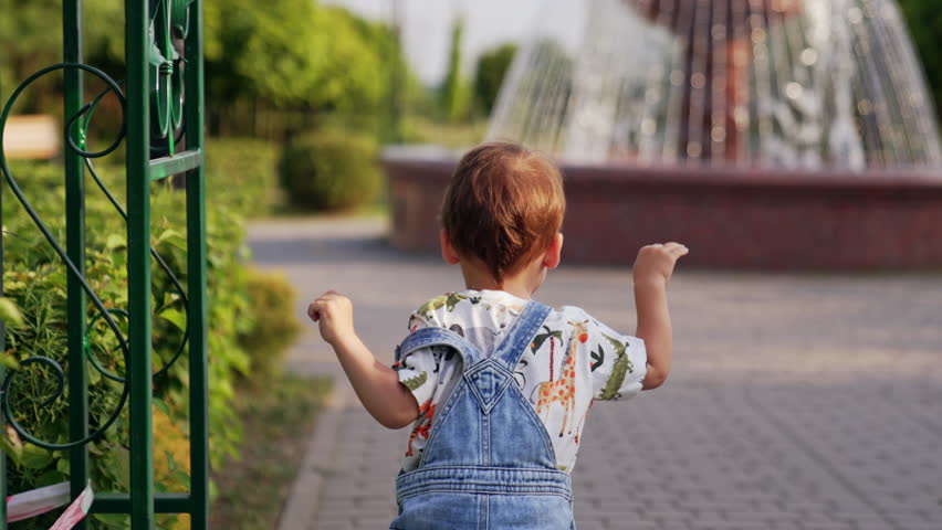 Child runs in park outside. Small boy running outdoor.