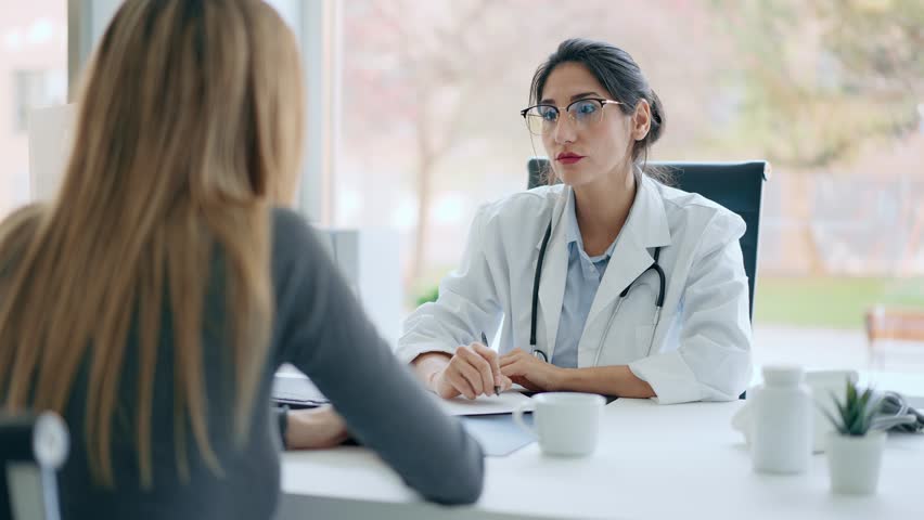Video of beautiful cheerful female doctor talking while explaining medical treatment to patient in the consultation. Royalty-Free Stock Footage #1105469359