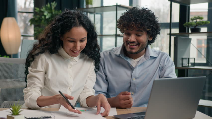 Multiracial business partners multiethnic colleagues Indian businessman and Arabian businesswoman working together paperwork in office happy team celebrate success achievement win startup on laptop Royalty-Free Stock Footage #1105471485