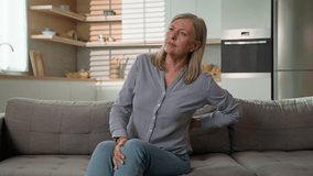 Unhappy mature caucasian woman feeling ache lower back pain on sofa at home unwell tired elderly female grandmother suffer from osteoarthritis arthritis lumbar spinal backache senior lady feel spasm - Powered by Shutterstock - Get 15% off with code: PIKWIZARD15