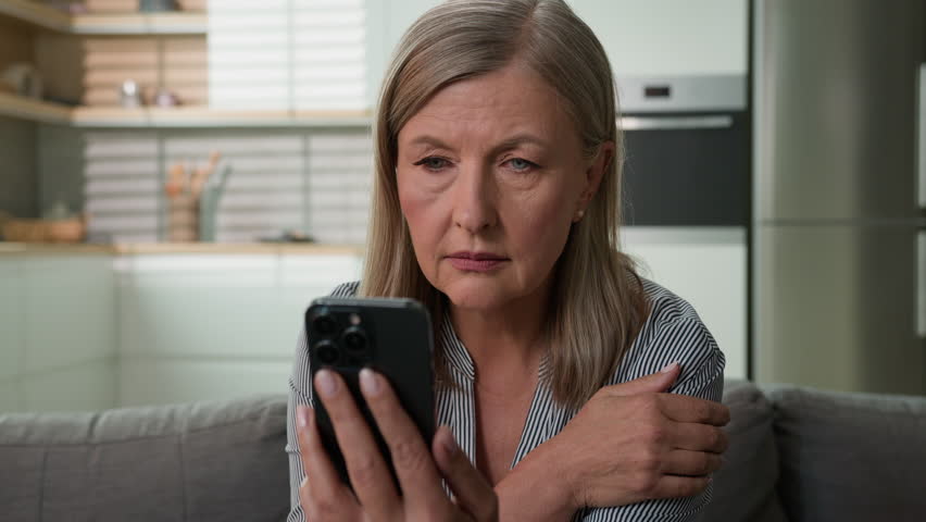 Worried frustrated senior woman reading bad news on mobile phone shocked elderly female looking at smartphone screen getting notification depressed by negative medical examination result bank debt Royalty-Free Stock Footage #1105471545