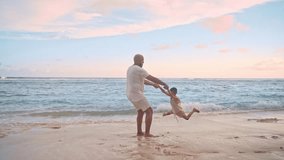 Happy Family at Ocean Water of Sea Beach. Parent Cares of Young Child on Summer Bay Vacation in Nature Outdoor. Man and Adorable Kid in Casual Clothes Have Fun Together on Weekend at Seascape Paradise - Powered by Shutterstock - Get 15% off with code: PIKWIZARD15