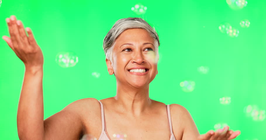 Old woman, bubbles and natural beauty, green screen with fun and playful, cosmetic care and skin on studio background. Happy female model, antiaging and freedom with glow, skincare and dermatology Royalty-Free Stock Footage #1105476509