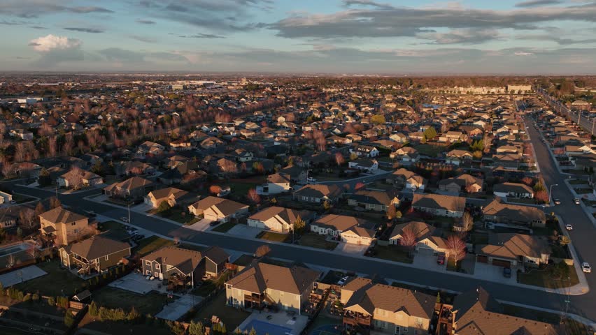 Orbiting aerial view of homes in Kennewick, Washington at SUnset. Royalty-Free Stock Footage #1105479675