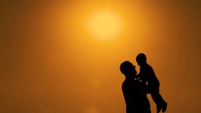 Silhouettes at sunset. Dad throws the baby up and spins with it. The concept is a happy family. 4k video.
