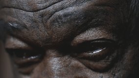 One black senior man gazing upwards with HOPE, macro close-up detail of wrinkled eyes in old age. African American person closing eyes in contemplation and mental reflection - Powered by Shutterstock - Get 15% off with code: PIKWIZARD15