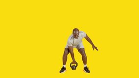 Sportive african man doing one arm swing with kettlebell