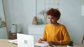African american girl using laptop at home office looking at screen typing chatting reading writing email. Young woman having virtual meeting online chat video call conference. Work learning from home