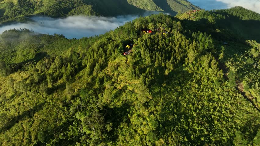 Aerial View of Mountains Above the Clouds at Sunrise. In the Mongkrang Hills, Indonesia