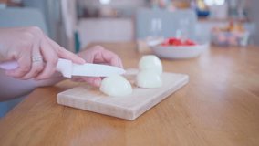 Rapidly Chopping Onion, Close-Up.  White onions close up. Female hands cut onions in kitchen. Macro shooting of red onions. The woman cuts onions on a wooden board. 4k video footage