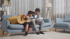 Full Body Of Asian Father Teaching His Son Playing The Guitar On Sofa At Home
 - Powered by Shutterstock - Get 15% off with code: PIKWIZARD15