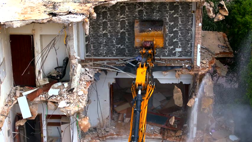 Excavator arm demolishing an old building, Aerial view Royalty-Free Stock Footage #1105499879