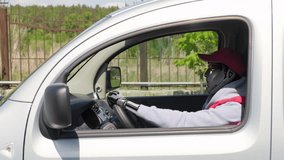 Side view neural network generated shot of humanoid robot wearing hoodie, red jacket and cap driving van on summer day - Powered by Shutterstock - Get 15% off with code: PIKWIZARD15
