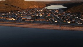 Aerial Newfoundland town of Placentia during sunset with distant landmarks and beaches overlooking bodies of water and peninsulas along the East coast of Canada.
