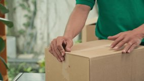 Close up shot of mail worker sealing cardboard box using tape before shipping to client at office - Powered by Shutterstock - Get 15% off with code: PIKWIZARD15