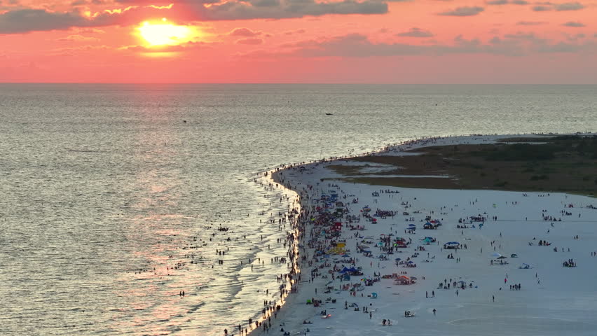 Aerial view of Siesta Key beach in Sarasota, USA. Many people enjoing vacation time swimming in gulf water and relaxing on warm Florida sun at sunset