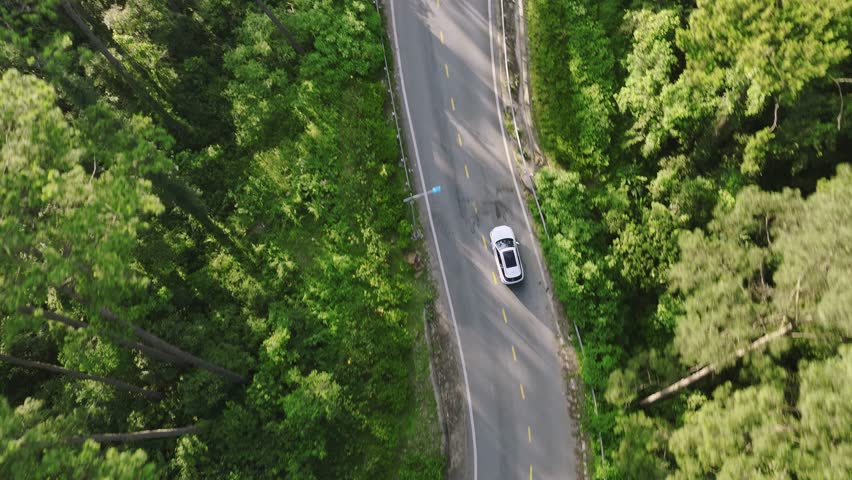 A car gracefully maneuvering along a winding mountain pass, embracing the thrill of the journey Royalty-Free Stock Footage #1105503973
