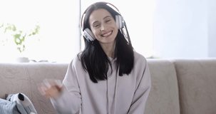 Woman in headphones makes video call and communicates online