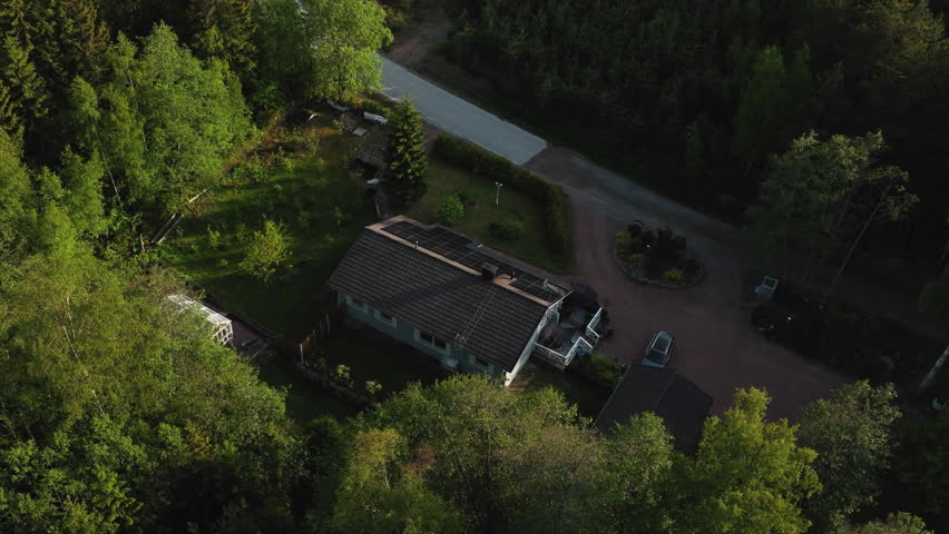 Aerial view descending in front of a detached house with a photovoltaic system