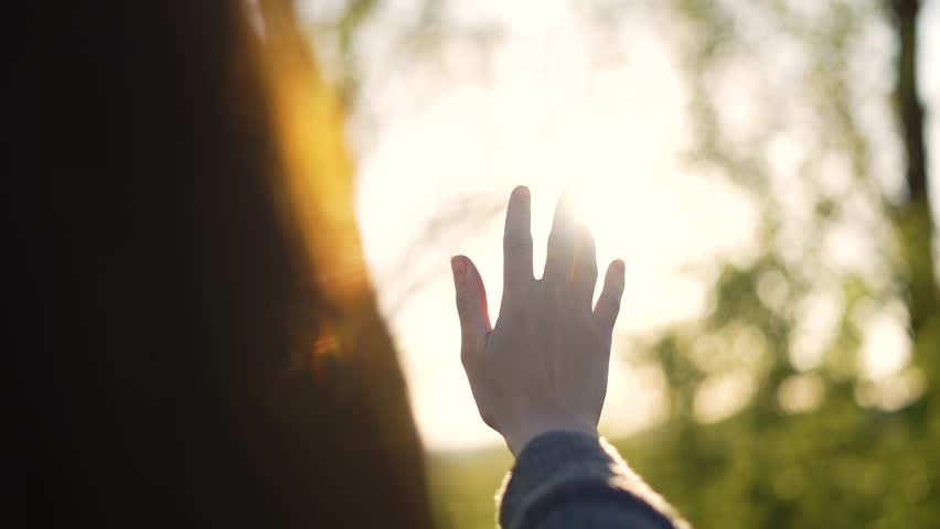 Hand of happy girl at sunset. Sunset between the hands of girl. Happy girl with long hair dreamily stretches out her hand to sun. Child's dream hand to the sun. happy family concept. Freedom in nature Royalty-Free Stock Footage #1105505785