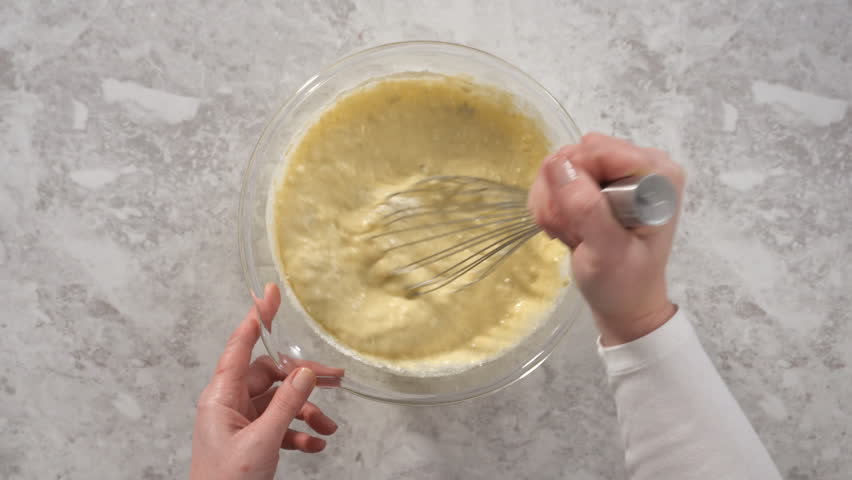 Time lapse. Mixing ingredients in a glass mixing bowl to prepare coconut banana pancakes. Royalty-Free Stock Footage #1105508043