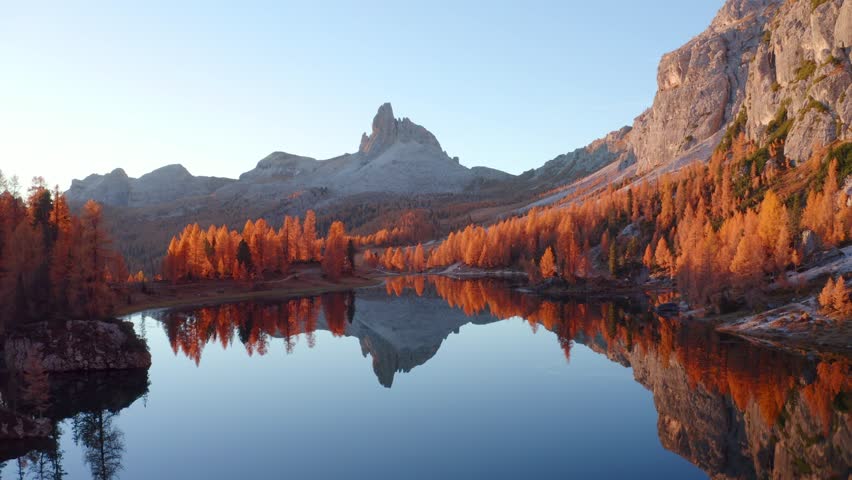4k drone forward video (Ultra High Definition) of popular tourist destination - Federa lake among red larch trees. Impressive sunrise in Dolomite Alps. Gorgeous morning scene of Italy, Europe.