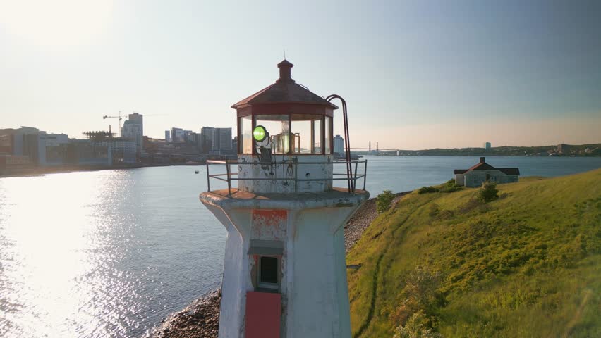 Lighthouse on Georges Island, Halifax, Canada. Calm Magical Sunset on a Small Island Overlooking the City with Skyscrapers. Aerial View of Breathtaking Natural Scenery with a Working Lighthouse.